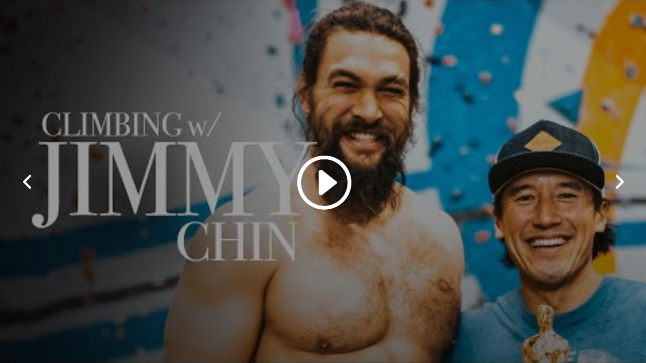 Two men smiling, one without a shirt